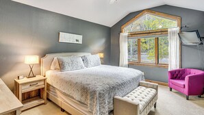 A bedroom with a large bed, a nightstand, a chair, a window with curtains, and a ceiling fan. - Rocky Mountain Retreat: 2 Mi to Beaver Creek! (Avon)