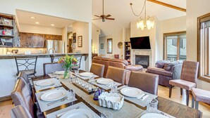 A spacious living area with a dining table set for a meal, a fireplace, and a television. - Rocky Mountain Retreat: 2 Mi to Beaver Creek! (Avon)