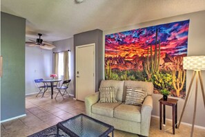 Relax in this inviting living room with a sofa, coffee table, and vibrant artwork.