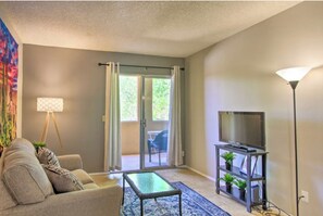 Relax in this cozy living space with a comfortable sofa, flat-screen TV, and floor lamp.