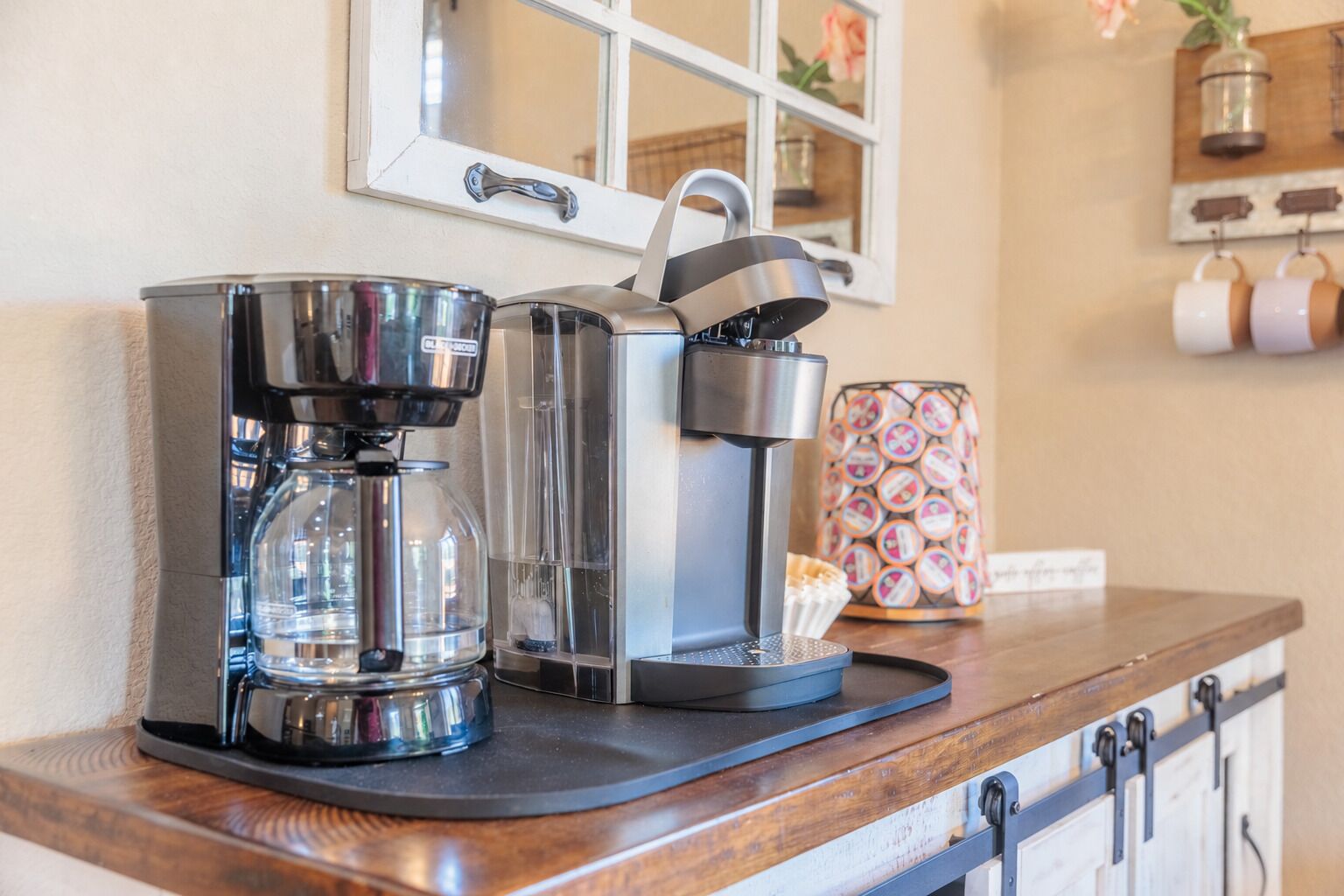Uma máquina de café e um bebedouro em uma bancada de madeira.