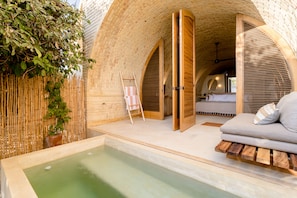 A spa area with a hot tub, wooden seating, and bamboo walls.