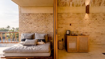 A room with a bed, a wooden cabinet, and a brick wall.