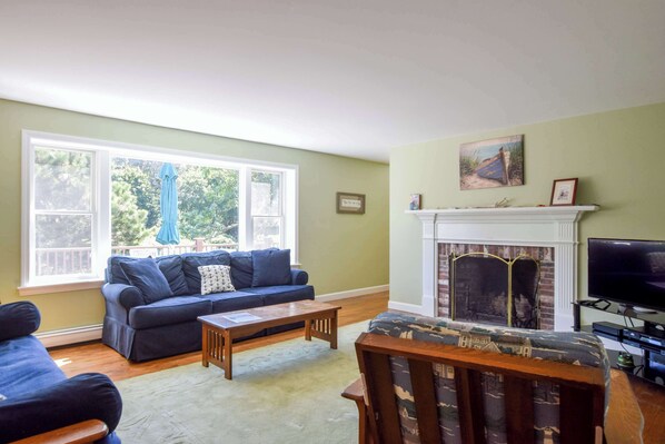 Una sala de estar con chimenea, un sofá, una mesa de centro y un televisor.