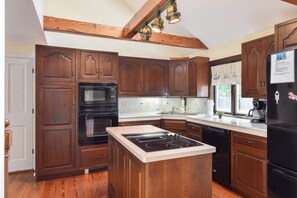 A kitchen with wooden cabinets, a built-in oven, a stove, and a refrigerator.
