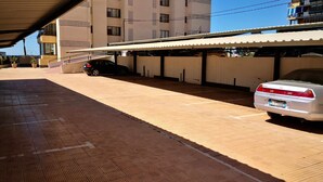 Ein Parkplatz mit überdachtem Gang und einem Gebäude im Hintergrund.