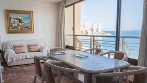 Ein Balkon mit Esstisch und Stühlen, einer Couch und einem Bild an der Wand.