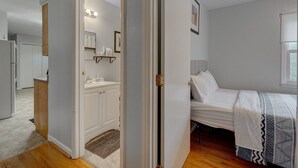 Een slaapkamer met een bed, een nachtkastje en een raam.