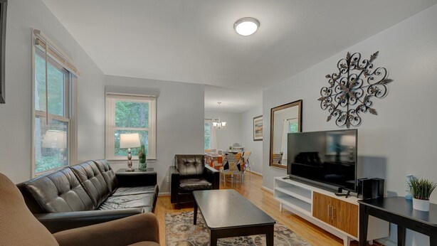 Een moderne woonkamer met een leren bank, een salontafel en een televisie op een dressoir.