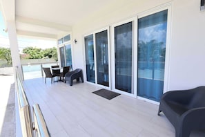Relax on the balcony with a view, featuring a clean floor, comfortable seating, and a small table.