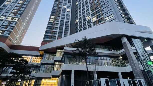 A modern high-rise building with a curved facade and multiple floors. - Landmark Stay in Songdo (Incheon)