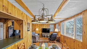 A cozy cabin interior with a dining area, kitchen, and living space.