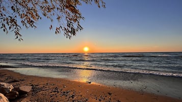 Ranta lähistöllä, aurinkotuoleja, rantapyyhkeitä
