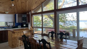 A wooden cabin kitchen with large windows overlooking a lake. - Water Access Only Cottage on Georgian Bay (Tay)