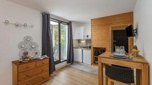 A modern kitchen with a microwave, a dining table with chairs, and a wooden cabinet.