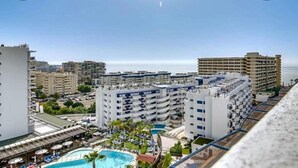 Un hôtel de grande hauteur doté de nombreux balcons, d’une piscine et offrant une vue sur la mer.