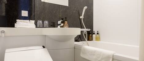 A modern bathroom with a toilet, sink, and shower.