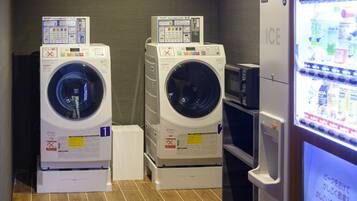 A laundry area with two stacked washing machines and a refrigerator.