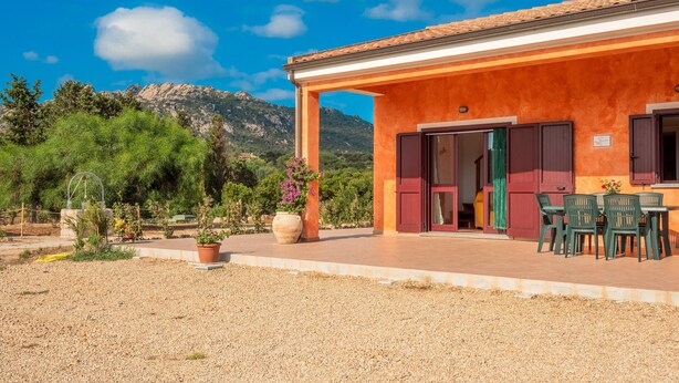 A building with a covered patio, outdoor seating, and a view of mountains.