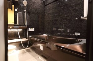 Une salle de bain moderne avec une grande baignoire sur pieds, une douchette et un miroir au-dessus du lavabo.