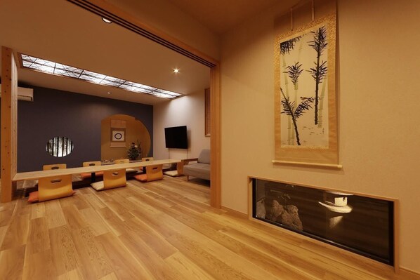 Un espace repas moderne avec une longue table en bois, des chaises rembourrées, un téléviseur à écran plat et une grande œuvre d’art sur le mur, dont le thème est le bambou.