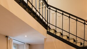A hotel lobby with a staircase, two striped sofas, a framed picture, and a reception desk. - Hotel Bellavista (Frascati)