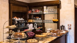 A breakfast bar with a coffee machine, pastries, and a glass display case. - Hotel Bellavista (Frascati)