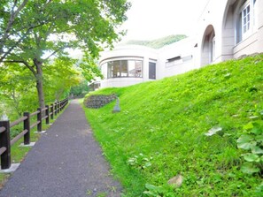 A pathway leading to a building with a curved facade and a stone wall. - For business  sightseeing  Breakfast included pl / Mombetsu-gun Hokkaidō (Mombetsu-gun)