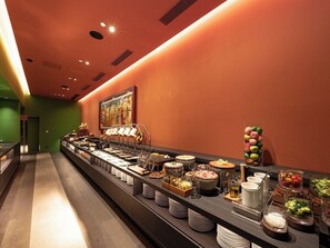 A buffet with various food items and a painting on the wall.