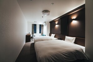 Two single beds with white linens and wooden headboards, a desk, flat-screen TV, and window with curtains.