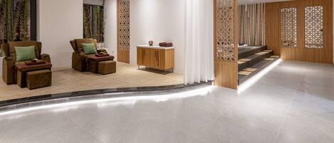 Un moderno espacio de spa con zona de estar, armarios de madera y un panel decorativo.