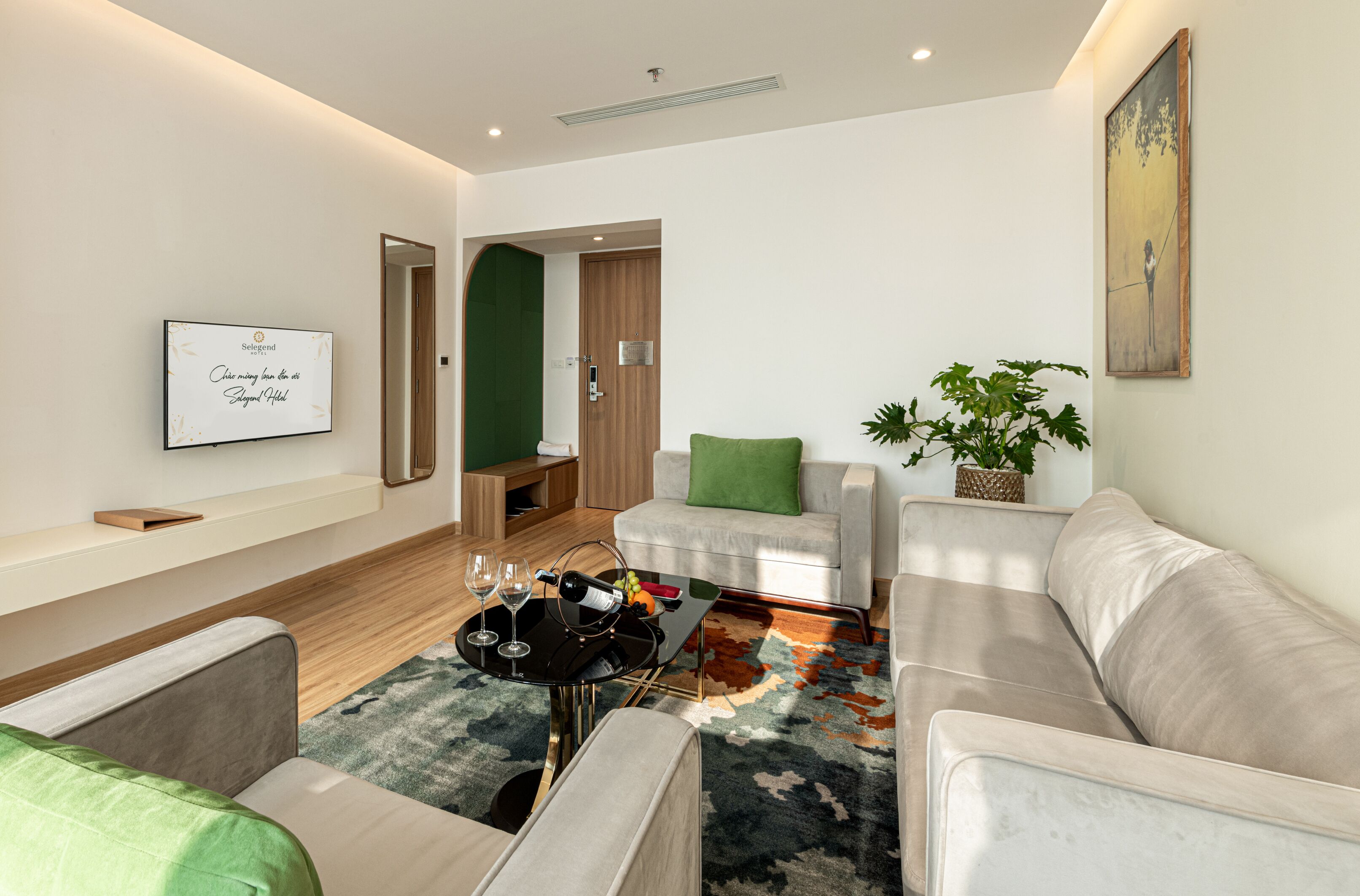 A modern living room with a sofa, a coffee table, and a TV mounted on the wall.