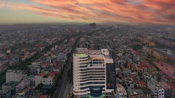 Un hotel moderno con un letrero llamativo, rodeado por una zona urbana densa con varios edificios.