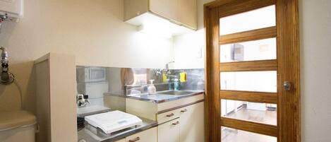 Kylskåp, mikrovågsugn, spishäll och grytor/köksredskap