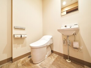 Une petite salle de bain moderne, équipée de toilettes, d’un lavabo et d’un miroir.