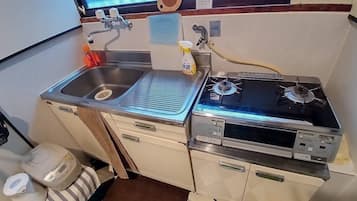 Een microgolfoven, een kookplaat, kookgerei, borden en bestek