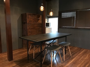 A dining area with a wooden table, two chairs, and a cabinet.