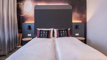 A hotel room with a large bed, two bedside tables, and a headboard with a unique design.