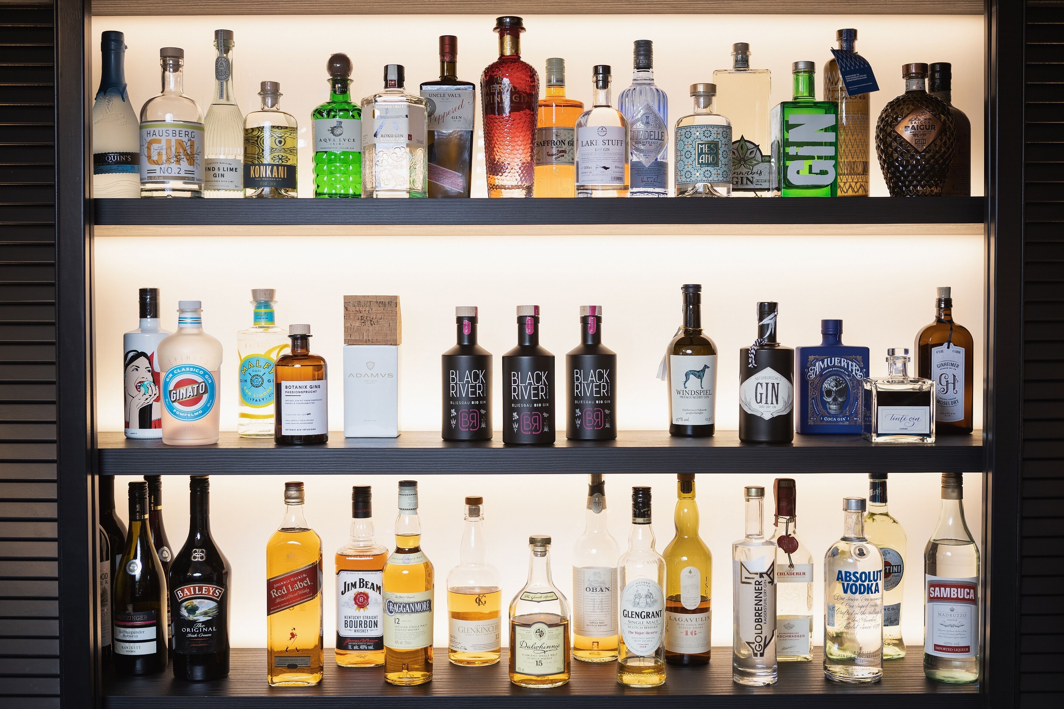 Una estantería con diferentes botellas de licor.