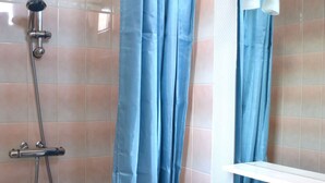 A bathroom with a shower, a sink, and a mirror. - 2 steps from the beach - Centre d'Asnelles (Asnelles)