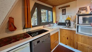 A modern kitchen with a wooden ceiling, a dishwasher, a stove, and a microwave. - Chalet for 6 with balcony and parking in Les Angles (Les Angles)