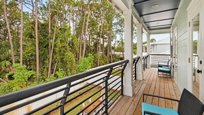 A covered outdoor deck with a railing, wooden flooring, and a view of a forested area. - ⭐6 Bedroom Beauty-Fab Interior-Great Outdoor Living Space-6 Bikes-6BR Cozy Shore (Miramar Beach)