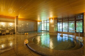 Relax by the pool surrounded by a stone wall, with benches for a comfortable spot to unwind.
