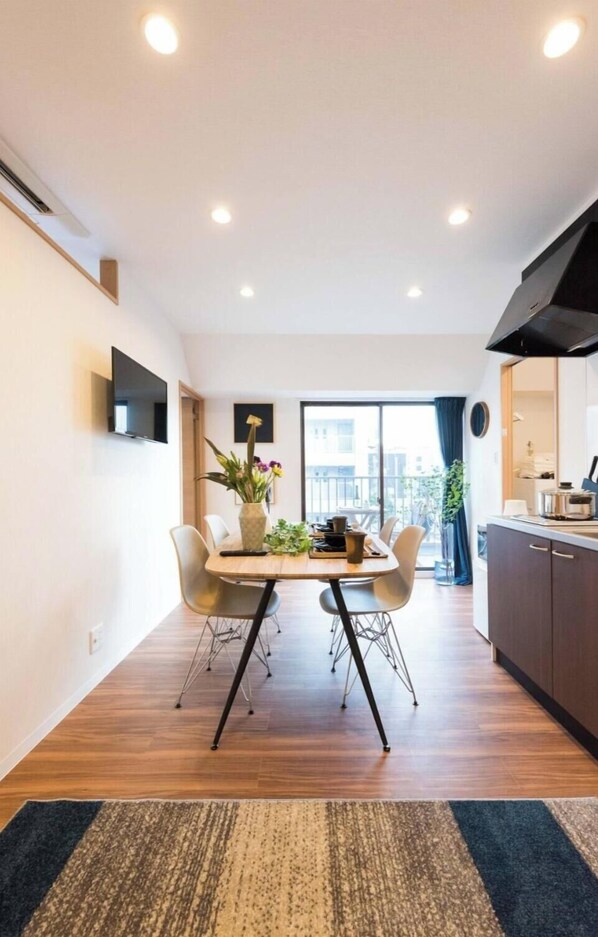 Una cocina moderna con comedor, televisor de pantalla plana y un ventanal con vistas.