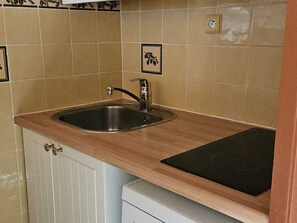A kitchen with a stainless steel sink, wooden countertop, and a white cabinet below. - Apartment on La Croisette: Ski-in/Ski-out, Sleeps 4, Free WiFi, Pet-Friendly (Les Menuires)