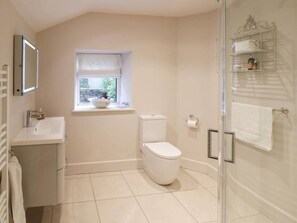 A modern bathroom with a toilet, sink, and shower.