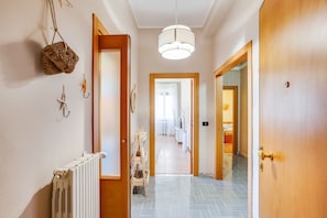 Stylish hallway with a radiator, wooden door, and patterned tile floor.