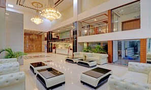 Un vestíbulo amplio con una mesa de recepción, zona de estar y detalles decorativos.