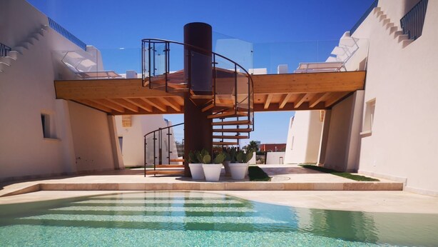 A pool area with clear water, a wooden staircase, and potted plants. - La Corte Residence (Salve)