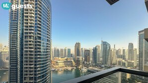 A high-rise building with a view of a cityscape and a body of water.